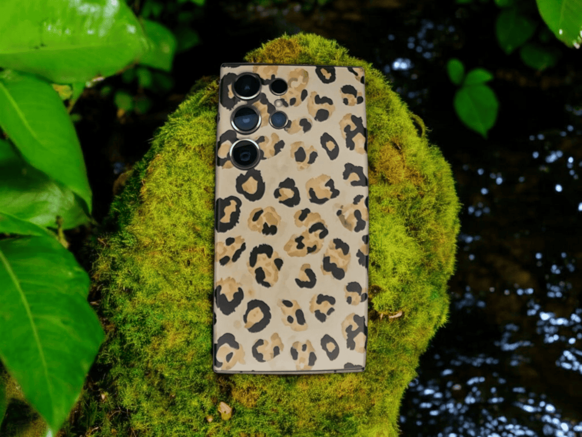 Leopardikuosinen Arctic Shield BackSkin puhelimessa luonnon keskellä – valmistettu Suomessa.